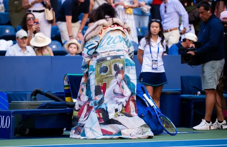 Rear view of Naomi Osaka’s colourful KidSuper coat and train on the tennis court