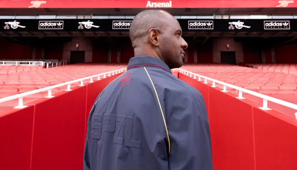 Rear view of Patrick Vieira’s navy Arsenal SPZL jacket with curved panels and a red neck logo